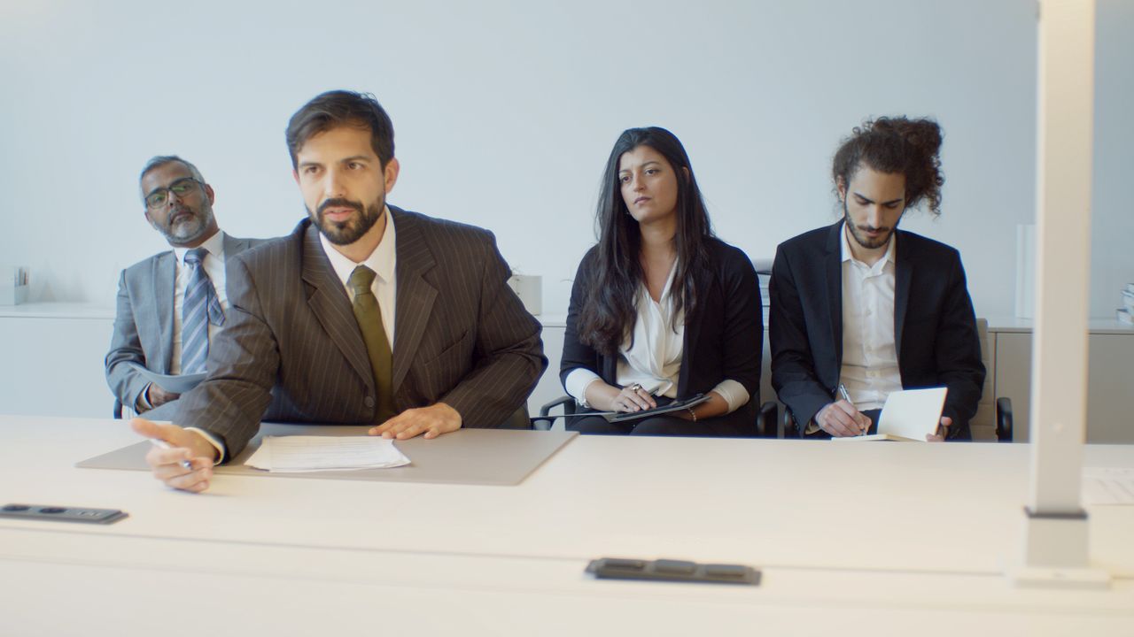 A diverse group of business professionals in a modern office setting, focusing on teamwork.