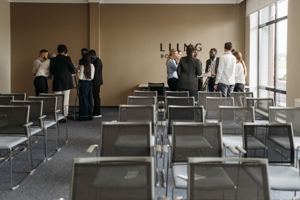 A group discussion taking place in a contemporary conference room with empty chairs.